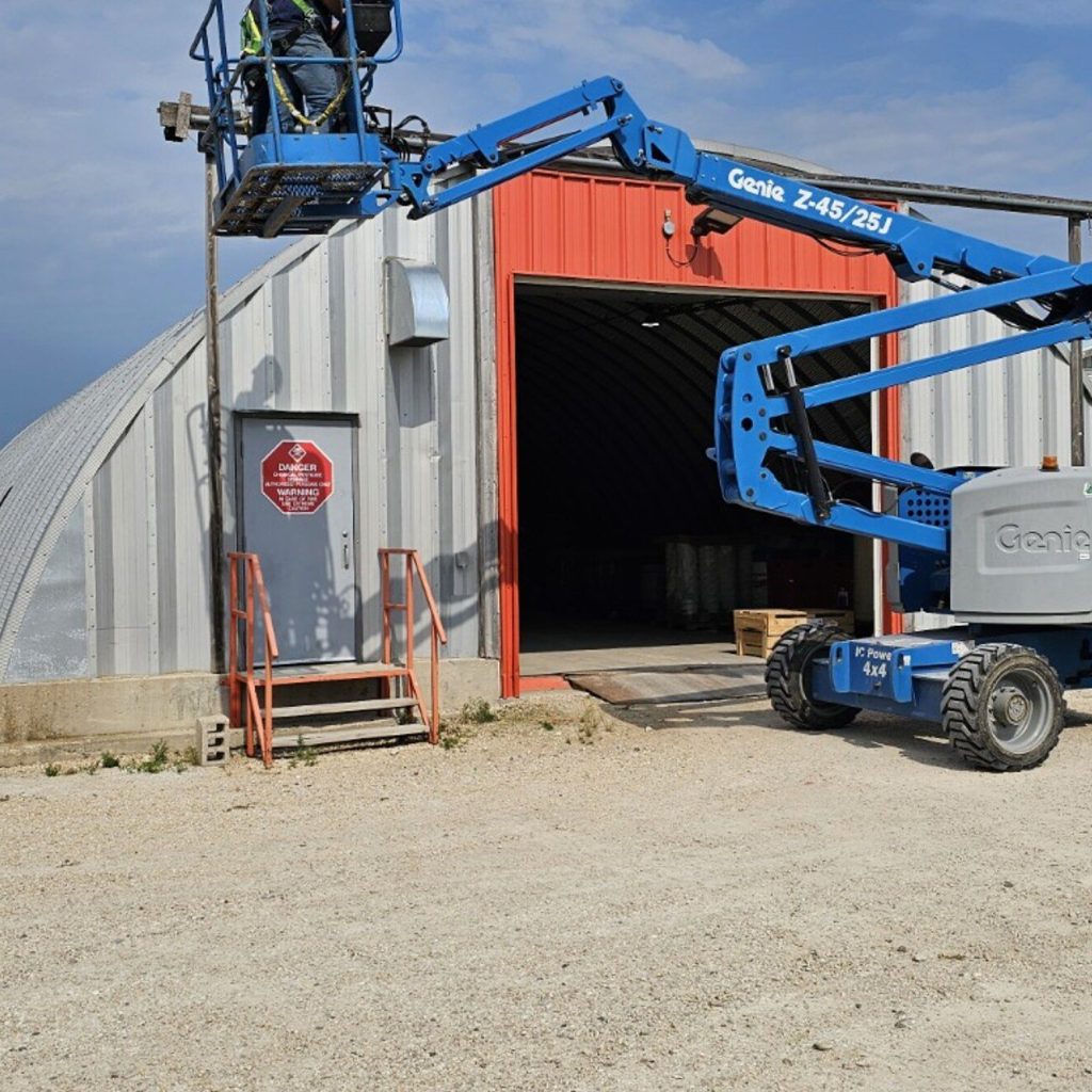 Boom lift parked outside a shop in Manitoba, used for aerial lifts train the trainer courses covering scissor and boom lifts