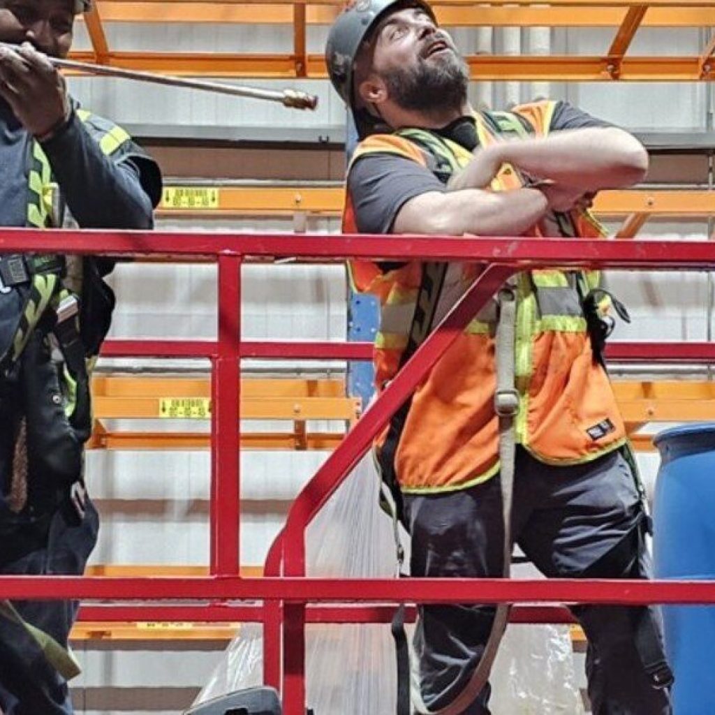 Two workers together on a raised scissor lift platform during a scissor lift train the trainer course in Winnipeg