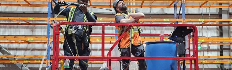Two workers together on a raised scissor lift platform during a scissor lift train the trainer course in Winnipeg